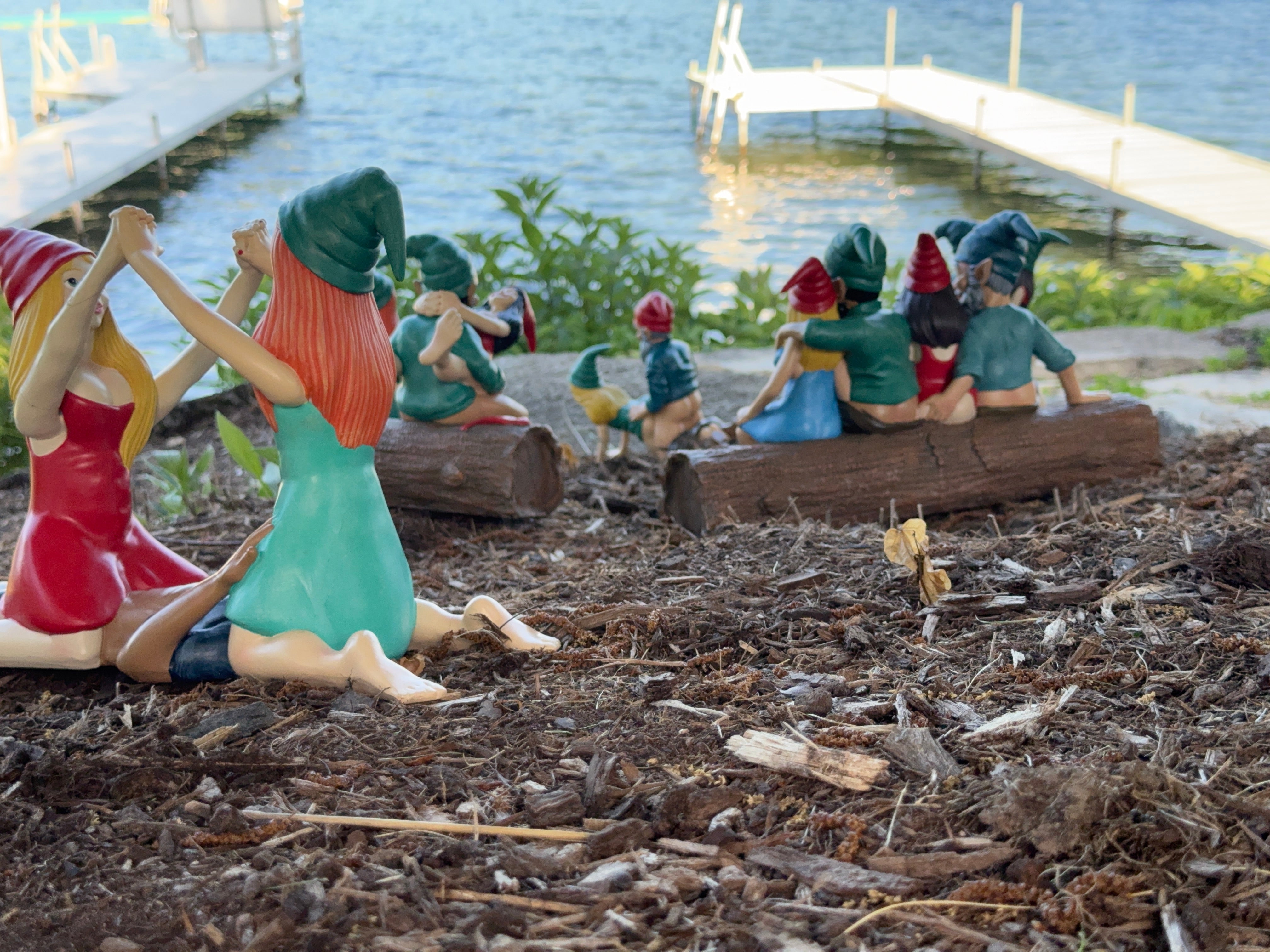 Colorful figurines of people by a pool with a tree in the background